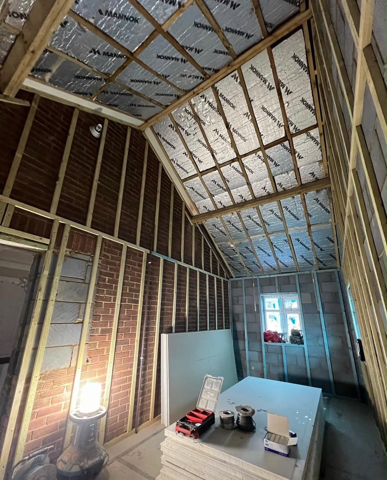 Loft conversion in progress with PIR insulation between rafters and stud walls