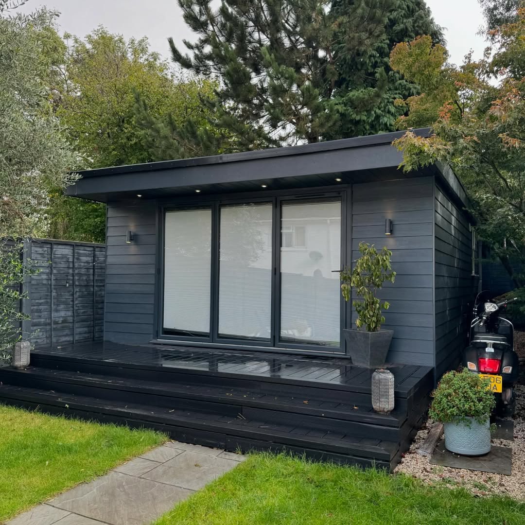 Finished luxury garden room in dark grey composite cladding with bifold doors and composite decking