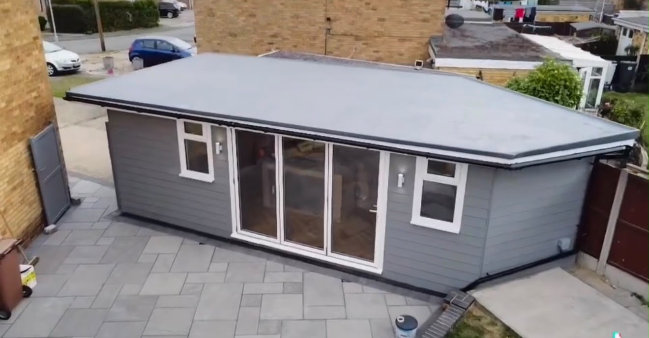 Aerial view of large grey clad garden room with flat fibreglass roof