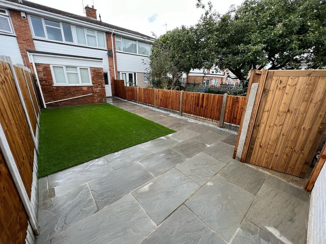 Finished landscaped garden with new Indian sandstone patio, artificial lawn and fresh fencing