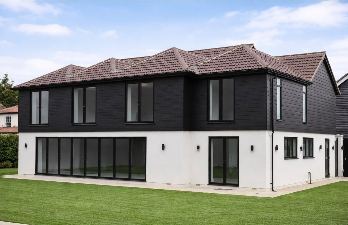 Completed two-storey new build home with black timber cladding and rendered base
