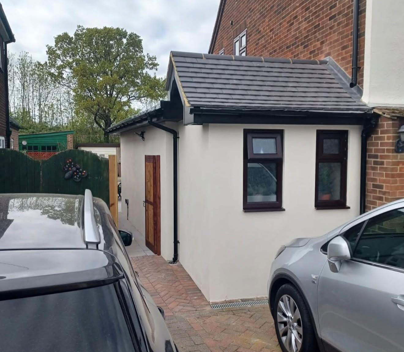 Side return refurbishment with smooth render, slate-tiled gable roof and hardwood door